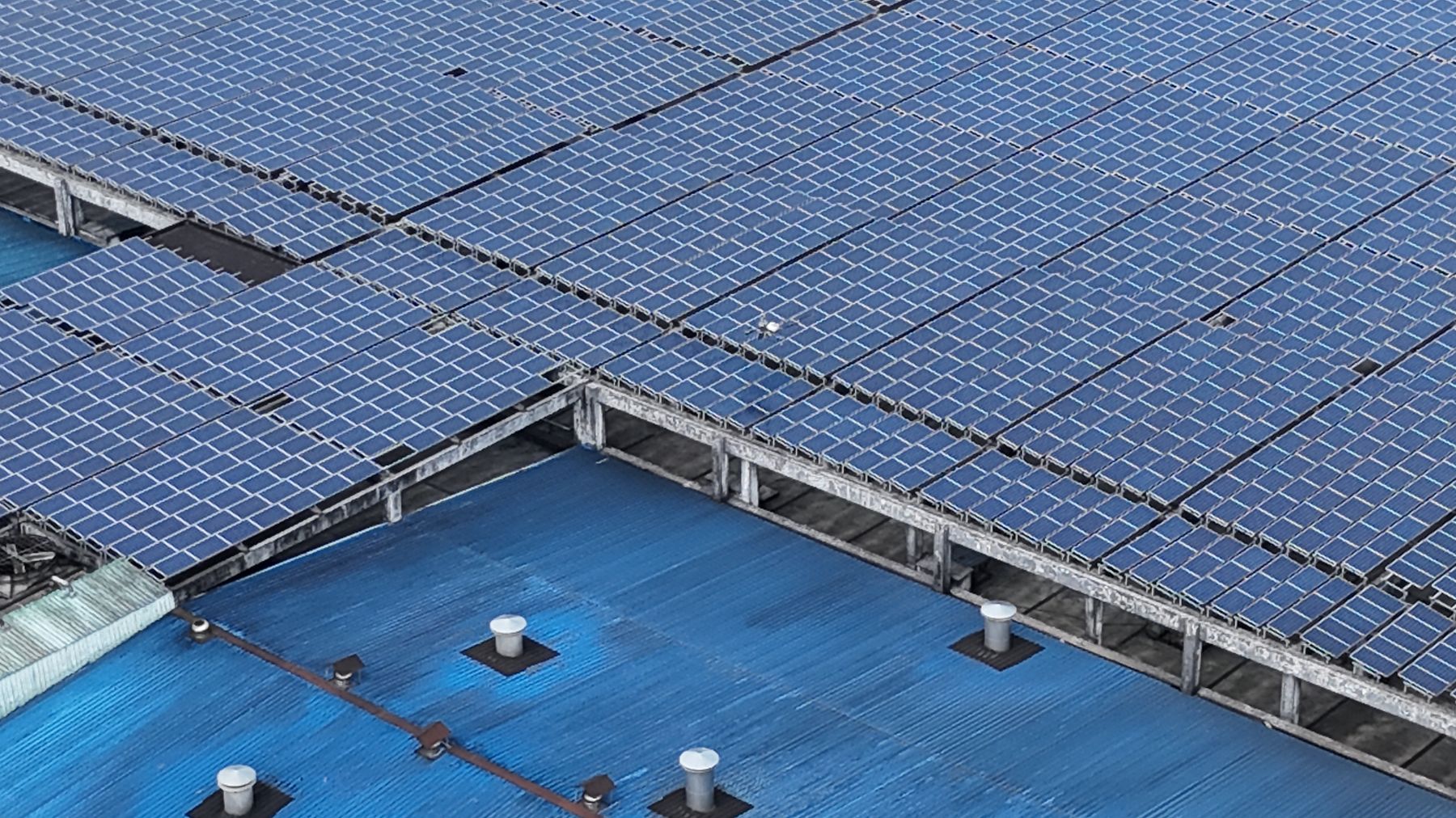 Aerial view of solar panels covering an industrial factory roof